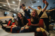 © qunica.com - Group of enthusiastic friends playing video games in a vibrant gaming lounge, celebrating their victory with joy and excitement. A scene showcasing fun, technology, and strong social connections.