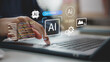 © FAMILY STOCK - Hand using laptop with AI interface and code on virtual screen, representing generative AI, prompt engineering, artificial intelligence development, automation, and machine learning technology.