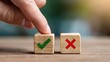 © Supernova - A hand pointing to two wooden blocks with a green checkmark and a red X sign on a desk