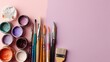 © mat - Art supplies, paint jars, brushes, and color palette on light pink background for creative projects and artistic inspiration