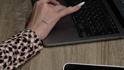 Computer technology and programming.
A girl taps her finger on a laptop keyboard in a dark workspace.
A girl in a leopard print outfit works in an office.