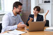 © New Africa - Consultant working with client at table in office. Business meeting