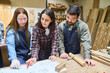 © Robert Kneschke - Young apprentices working together with mentor in lumberyard