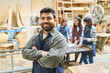 © Robert Kneschke - Confident worker in a bustling lumberyard teamwork setting