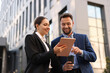 Coffee to go. Man with paper cup of drink and his business partner during meeting outdoors, low angle view