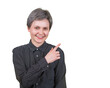 © 1STunningART - Positive young woman with short hairstyle, pointing forefinger aside, looking joyful to camera, wears dotted black shirt, isolated on transparent background with copy space