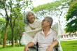 © PIC SNIPE - Happy Asian Senior Couple Relaxing Together in Park with Wheelchair