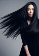 © Julija - Asian woman with long black hair blowing against a gray background for beauty and fashion content.