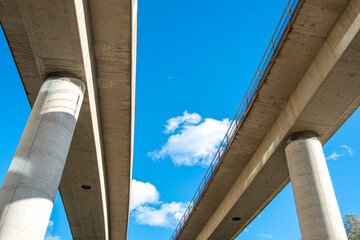 Elevated highway with concrete pillars against blue sky in Stockholm, Scandinavian urban infrastructure highlighting geometry, perspective, clarity and background copy space for design use
