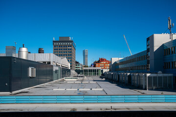 Wide rooftop perspective in Stockholm with infrastructure lines and towers, Scandinavian cityscape showing modern architecture, clarity, geometry and background copy space for graphic design