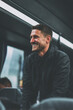© Starmarpro - Smiling Man in Transit: A candid moment of a happy, well-groomed man riding a bus or train, exuding joy and positive vibes during travel.