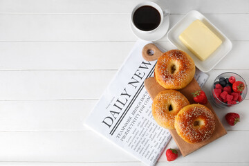 Wall Mural - Board with tasty bagels, berries and butter on white wooden background