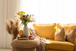 © Pixel-Shot - Vase with autumn flowers and pumpkins on table in living room interior