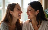 Young two women laughing and looking at each other. High quality