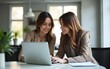 © wang - Two beautiful business women working together with laptop while talking about job news in the office. High quality