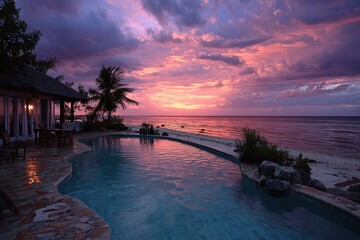 Wall Mural - Tropical resort pool during a vibrant pink and purple ocean sunset. Ideal for luxury travel, vacations, or destination wedding promotions.