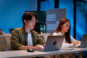 Asian software engineer or programmer team working late in development office,problem solving or algorithm of ai assistant helping for work.software developer,digital technology security concept