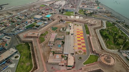 Wall Mural - A high-altitude aerial shot tilts down to reveal the entire star-shaped layout of the historic Real Felipe Fortress, a massive colonial bastion protecting the port of Callao in Lima, Peru
