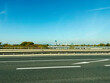 Driving on a sunny highway toward a distant city skyline under a clear blue sky in Vienna, Austria.