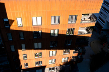 Red façade with windows and balconies, contemporary housing design showing clarity, geometry, copy space and modern architectural detail background for posters, templates and design
