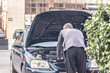 © Mikhail - Man try fix car breakdown on road side at city street.