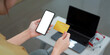 © Natee Meepian - Online shopping. Holding a credit card and smartphone while making a purchase.