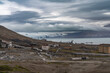 © Travel 'n' Lifestyle - View of abandoned buildings stand in stark contrast against the rugged, desolate landscape, with glacial mountains fading into the cloudy horizon, Pyramiden, Svalbard, Svalbard and Jan Mayen.
