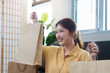 © Natee Meepian - Shopping: Happy woman holding shopping bags after online purchase