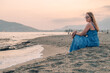 Woman sits on the beach and looks at the sea in Alanya city