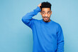 © ViDi Studio - Young sad man of African American ethnicity he wear sweatshirt casual clothes put hand on head scratch temple look aside isolated on plain pastel light blue cyan background studio. Lifestyle concept.