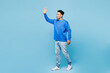 © ViDi Studio - Full body side view young man of African American ethnicity wear sweatshirt casual clothes walk go waving hand isolated on plain pastel light blue cyan background studio portrait. Lifestyle concept.