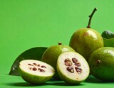 Fresh green Garcinia fruits, one halved, showcasing exotic flavors and vibrant freshness for culinary delights