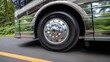 © Justlight - Medium shot showing the regenerative braking system on an RV wheel in motion focus on the sensor and brake components with the road and vehicle blurred.