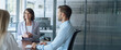 © Stock 4 You - Team of young European man and Latin businesswoman discussing project sitting at table in office. Business people work together. Female woman mentor leader coach have meeting. Banner, copy space