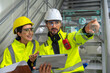 © Golf_MHNK - A Latin American man and woman, both engineers, inspect the chiller system using a laptop, focusing on compressors, condensers, and temperature control in a manufacturing plant.