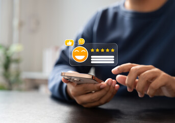 Canvas Print - Customer giving 5-star rating on smartphone screen with smiley emoji icon, symbolizing excellent user feedback, satisfaction review, and positive digital reputation.
