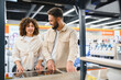 © Serhii - Couple choosing induction stovetop in electronics store
