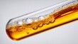 © Visglow - A test tube filled with golden liquid creates bubbles, perfect for scientific concepts and medical use.