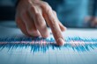 © Promptalo - A hand points to a colorful seismograph reading, analyzing earthquake data or seismic activity on a graph