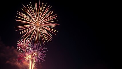 Vibrant fireworks exploding in a night sky, creating colorful sparks and dramatic light trails.