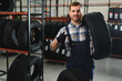 © Serhii - Hardworking experienced worker holding tire and he wants to change it In the tire store. Selective focus on tire