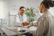 © Miljan Živković - Doctor shaking patient hand during office consultation