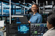 © DC Studio - Happy specialist inspecting neural network data center used for machine learning. Portrait of smiling engineer doing maintenance on server hub to optimize it for artificial intelligence workloads.