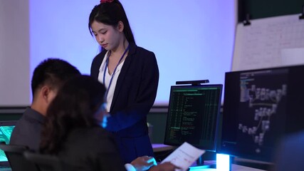 A female tech lead or scrum master leads a sprint planning meeting, explaining the codebase on a large screen and outlining new features for her development team in an agile company.