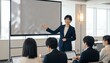 © Yka - 会議室でプロジェクターを使いプレゼンする女性