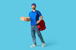 © Pixel-Shot - Male courier with pizza boxes on blue background