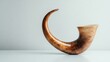 © wahyu - A traditional shofar with a curved shape, space for text on the right, set against a white surface