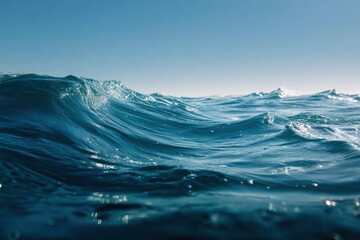 Wall Mural - Ocean waves rolling gracefully under a clear blue sky at midday, showcasing the beauty of coastal tranquility and nature's rhythm in serene surroundings