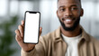 © Ali Hamza Tullah - Professional 3D style scene of cheerful African man showing smartphone with empty copy space screen for customization modern casual outfit minimal clean background concept of mobile application advert