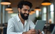 © Maria - Smiling indian businessman working on tablet and smile. High quality